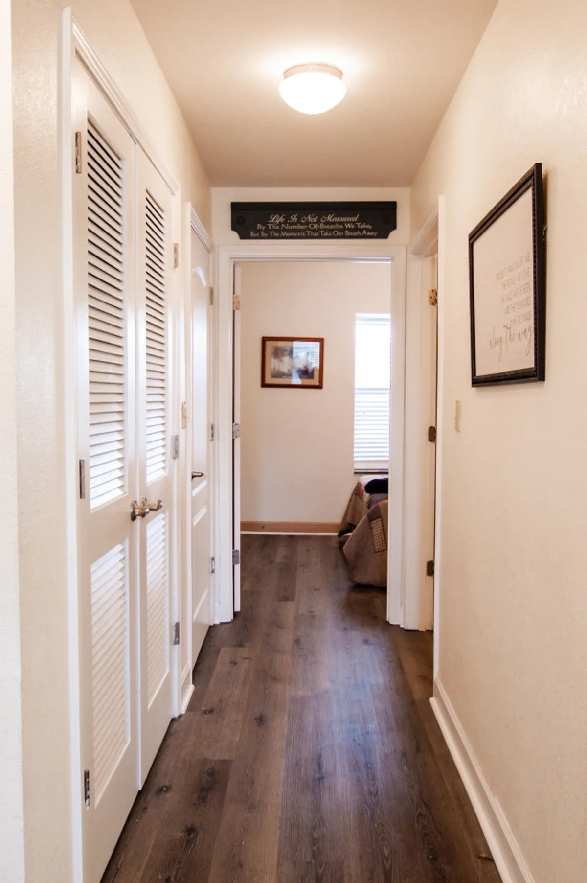 A welcoming interior hallway with stylish light fixtures, decorative signs, framed artwork, and doors leading to other rooms—suggesting accessible, easy navigation and a warm, inclusive atmosphere.